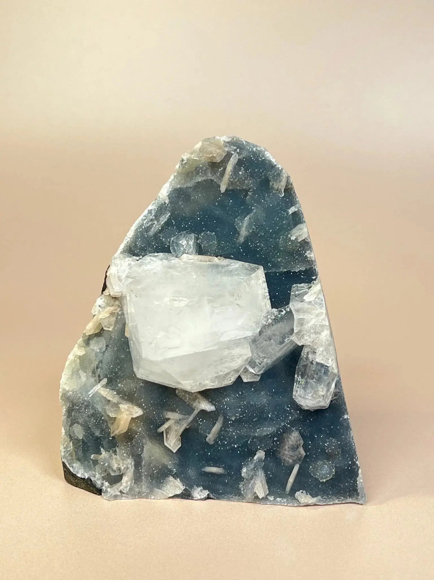 Chunky apophyllite crystal on blue chalcedony mineral specimen, isolated background