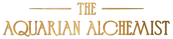 Gold art deco style text logo reading 'The Aquarian Alchemist' on transparent background