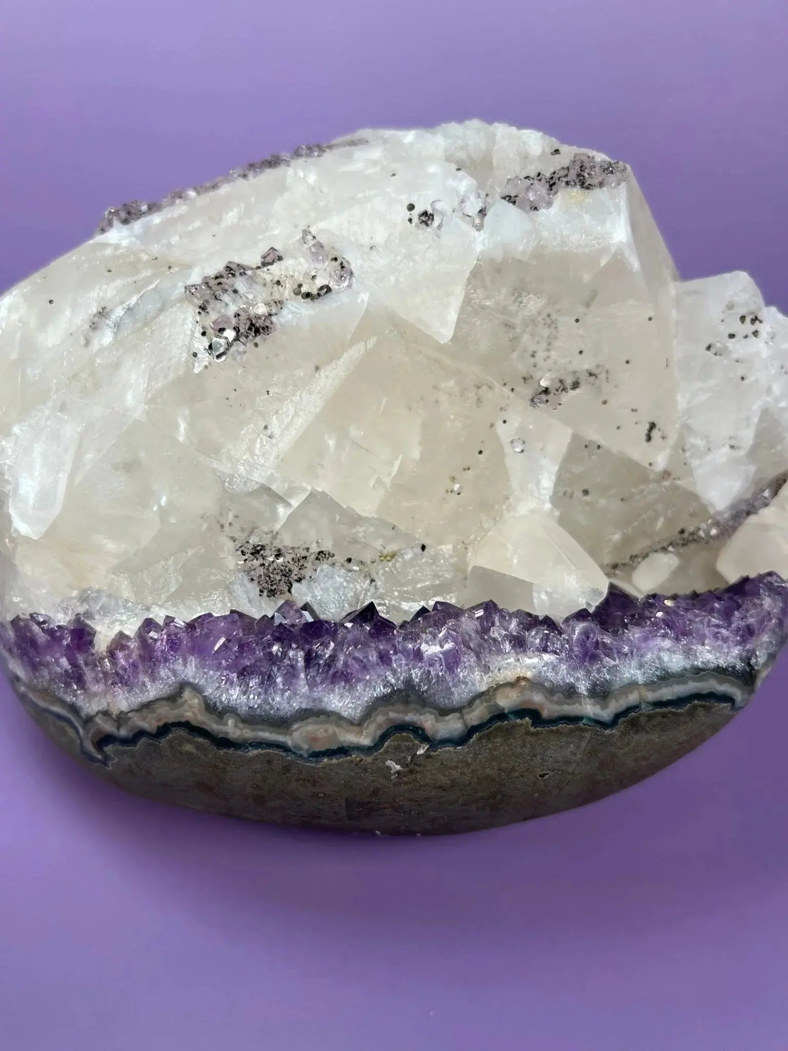 Brazilian amethyst and calcite cluster with goethite inclusions on purple background