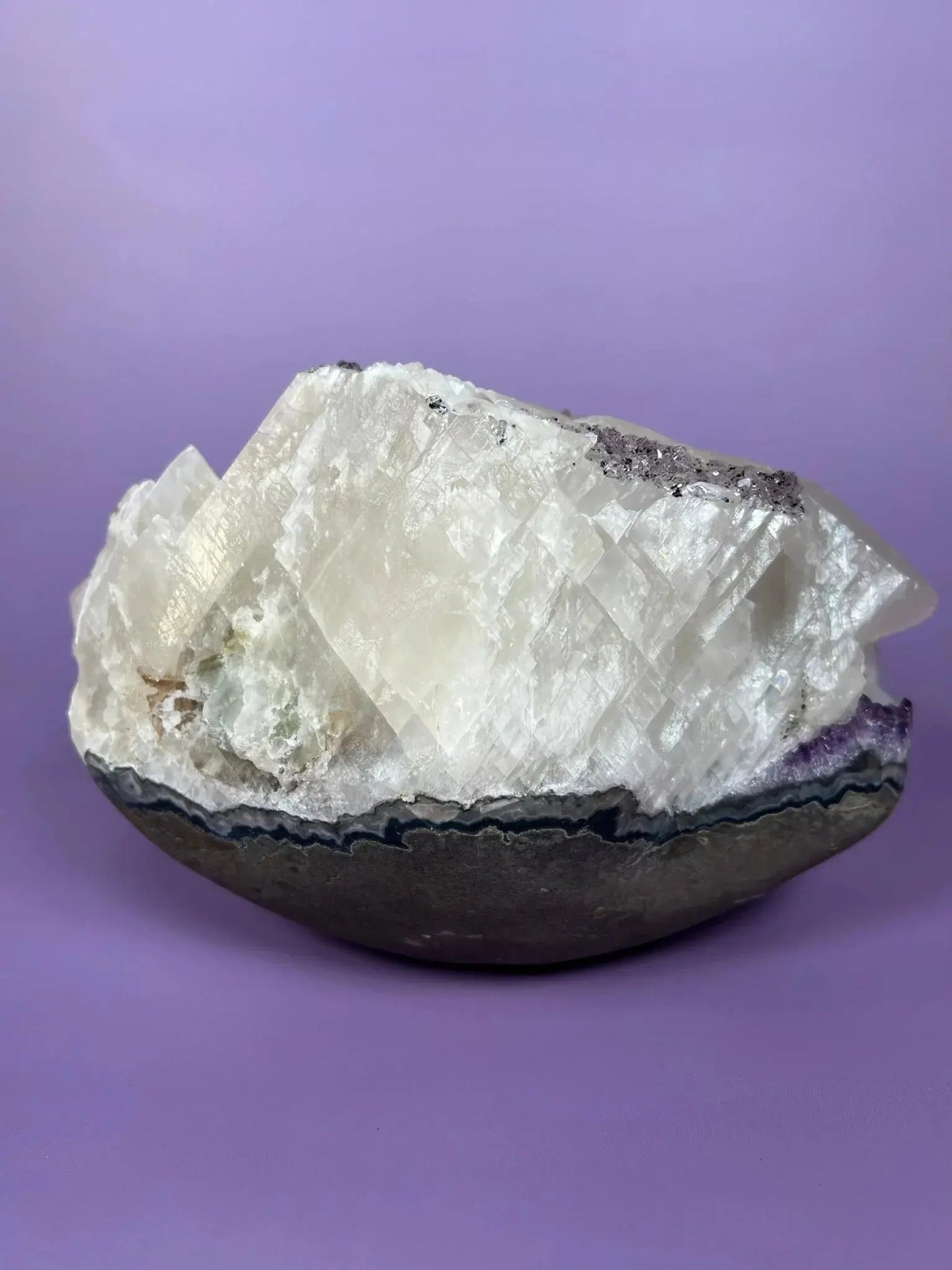 Brazilian amethyst and calcite cluster with goethite inclusions on purple background