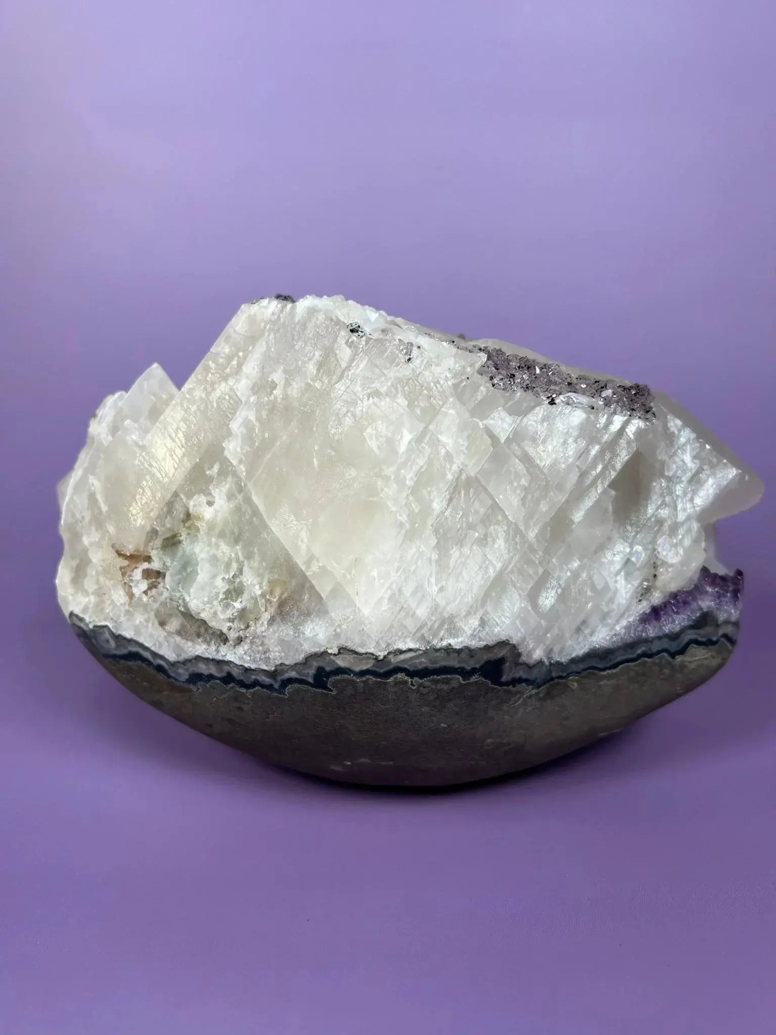 Brazilian amethyst and calcite cluster with goethite inclusions on purple background
