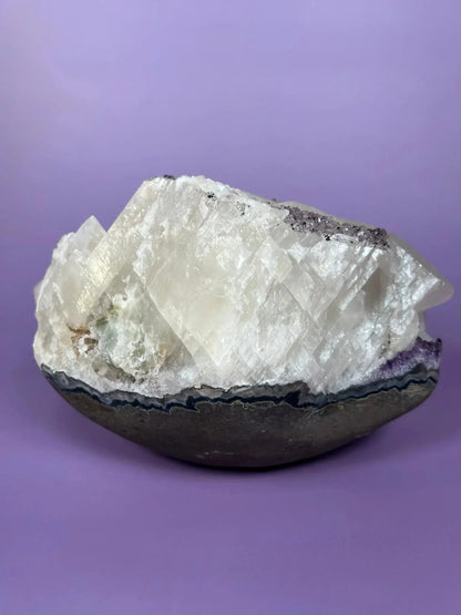 Brazilian amethyst and calcite cluster with goethite inclusions on purple background